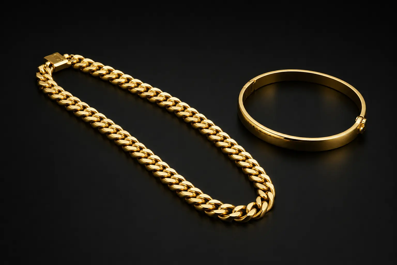 Classic gold curb chain and hinged bangle on a charcoal background